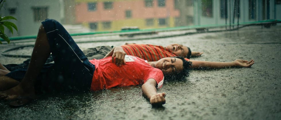 A couple laying on the ground in the rain laughing