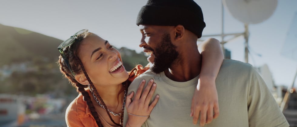 A woman and a man laughing together, fitting their personality traits in dating.