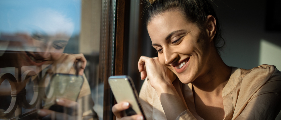 A woman smiling at her phone