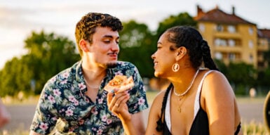 A couple sitting and eating pizza, enjoying quality time together