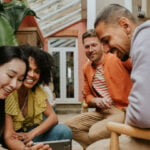 a group of people sitting and looking at a phone together