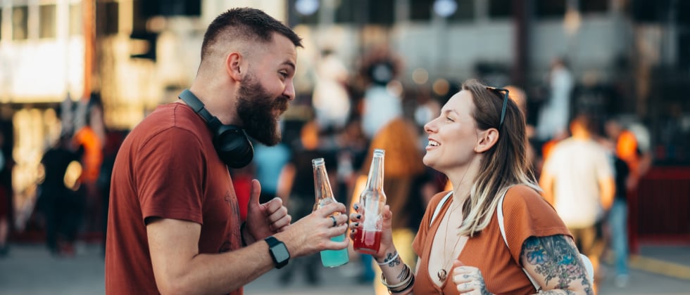 Man and woman outside toasting with drink to symbolise where to meet men