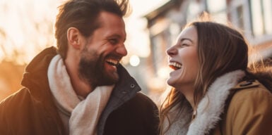 A man and a woman are looking at each other and are laughing