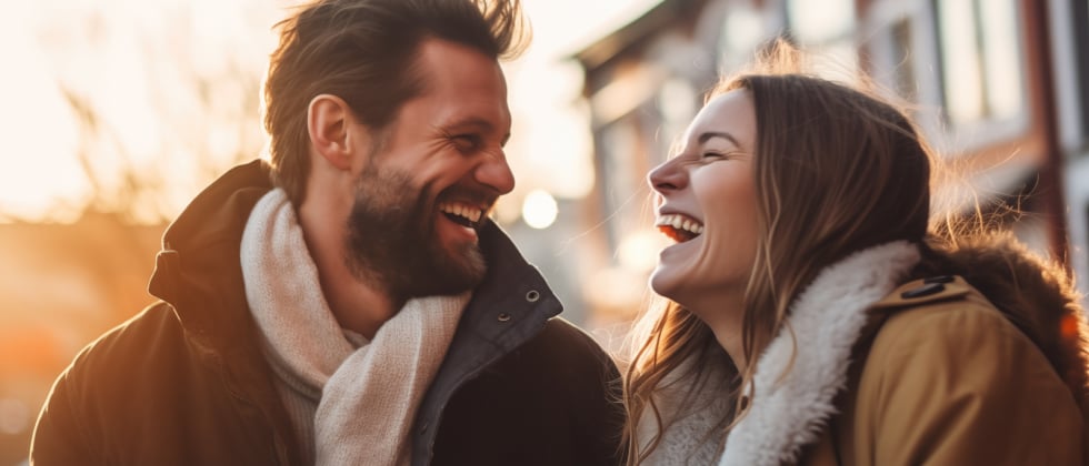 A man and a woman are looking at each other and are laughing