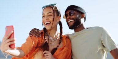 A man and a woman hug each other and laughing while taking a photo.