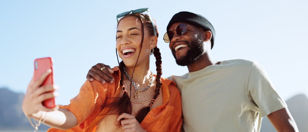 A man and a woman hug each other and laughing while taking a photo.