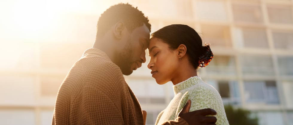 A woman and man leaning their forheads at each other, symbolizing "how to make someone fall in love with you"