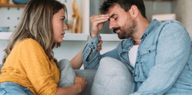 Man and woman sitting on sofa and man looking thoughtful as symbol for dating after divorce